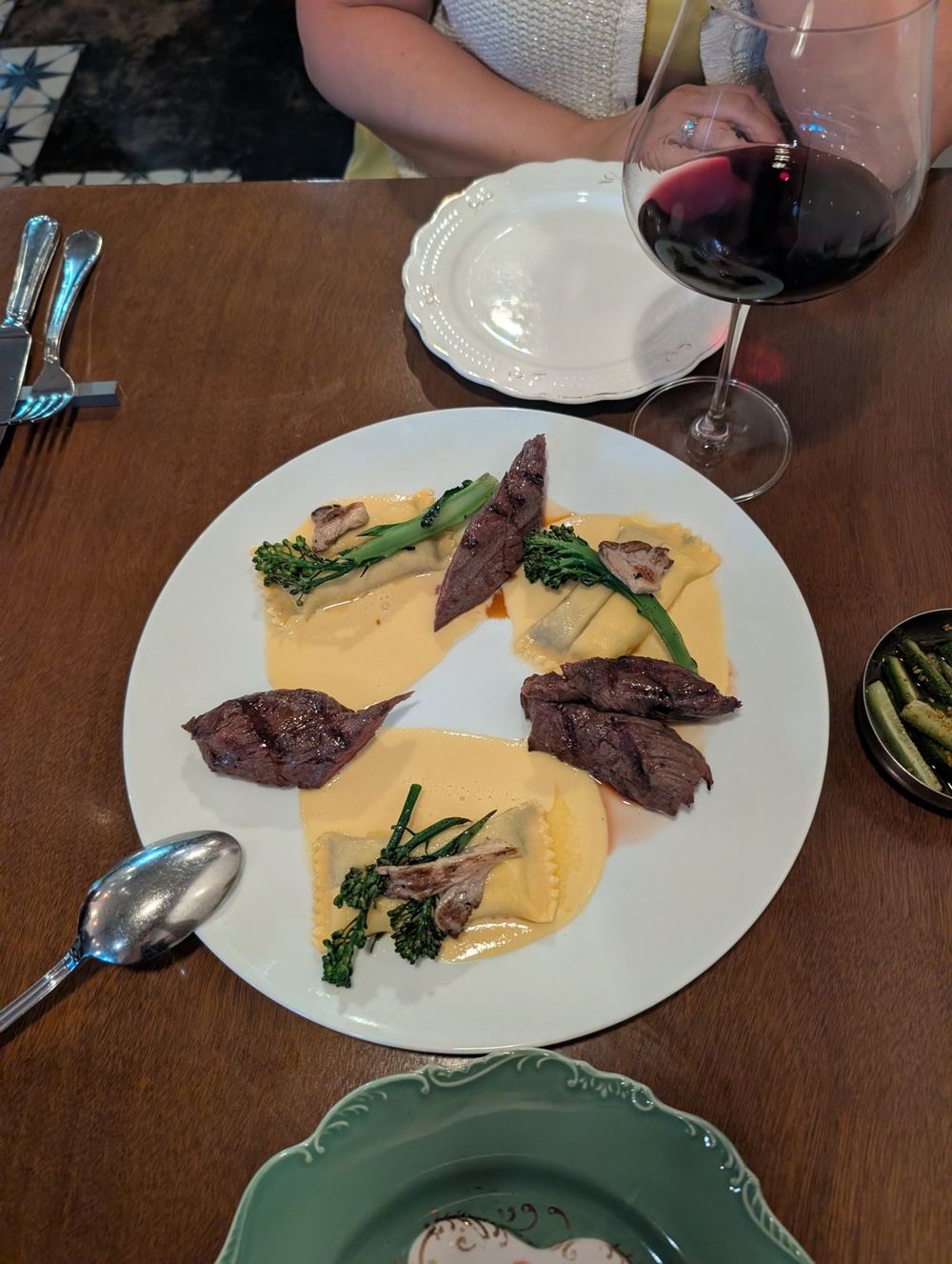 Hanger steak with mushroom ravioli in corn velouté with broccolini