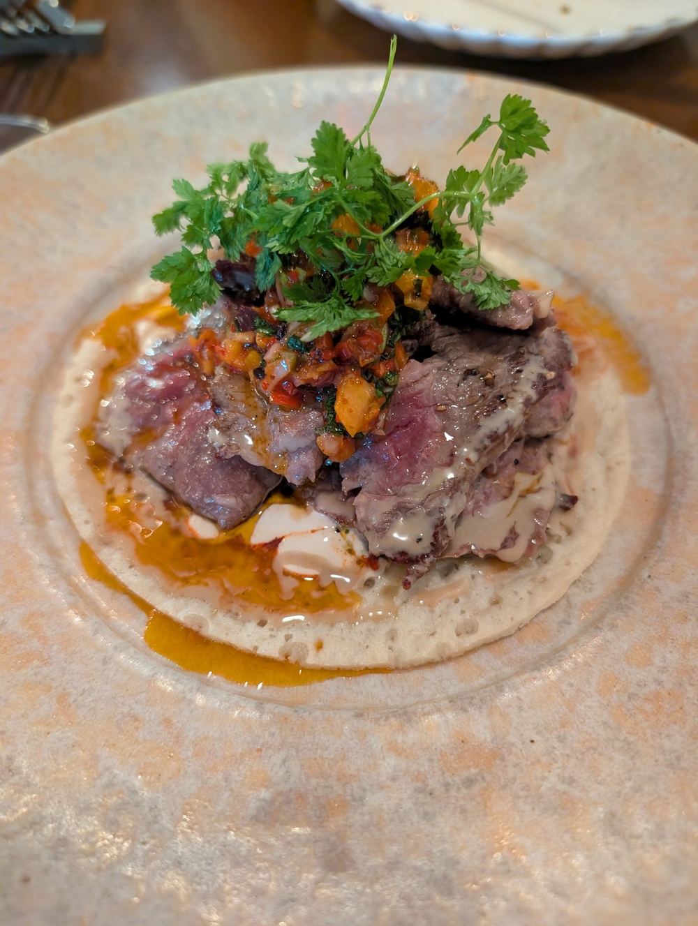 Steak on a Yemeni pancake with tahini and amba